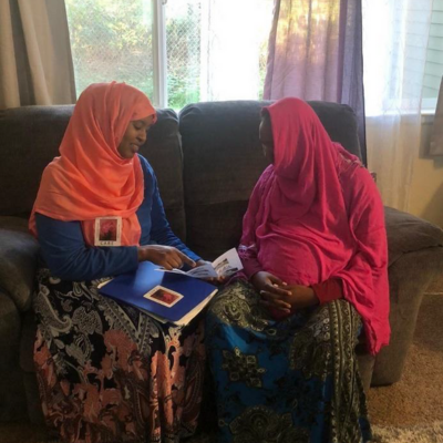 Two women from the Mama Amaan project, looking over photos. 