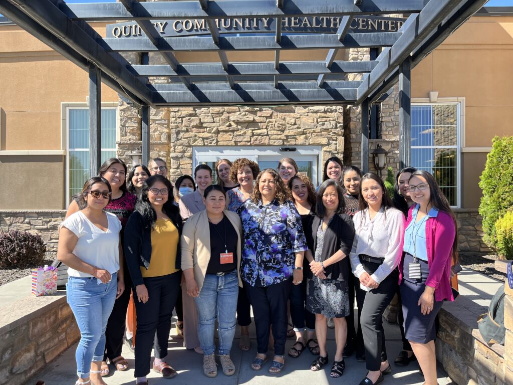 Group of women gathers for a photo in front of the Quincy Community Health Center