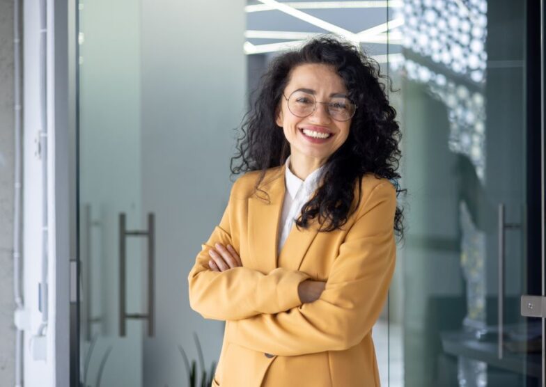 Womanbusprofessioanl Young woman legal professional wearing yellow blazer smiles at camera.