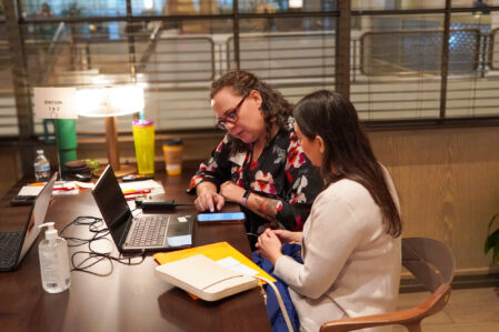 Resume workshop at Dress for Success Opportunity Fair Mentor guides opportunity affair attendee on ways to improve her resume.